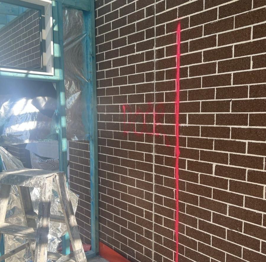 Brick wall marked out in red for a new door opening